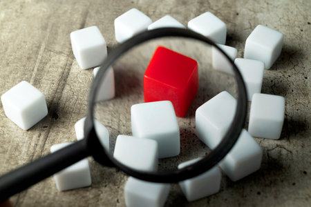 Magnifying glass focuses on small cubes on a wooden table