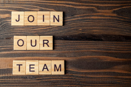 Wooden cubes with Join Our Team letters on a wooden table. Human resources management concept