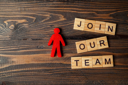 Wooden figures and wooden cubes with Join Our Team letters on a wooden table. Human resources management conceptの写真素材