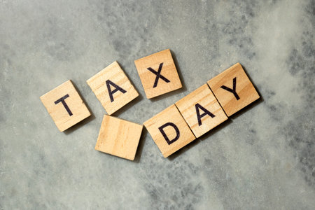 Close-up view of wooden cubes with TAX DAY letters. Financial conceptの写真素材