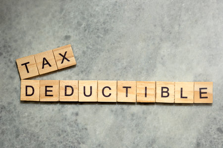 Close-up view of wooden cubes with TAX DEDUCTIBLE letters. Financial conceptの写真素材