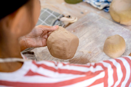 Closeup view of kids making a craft of a porcelain mug from wet clay. Pottery craft clay conceptの写真素材
