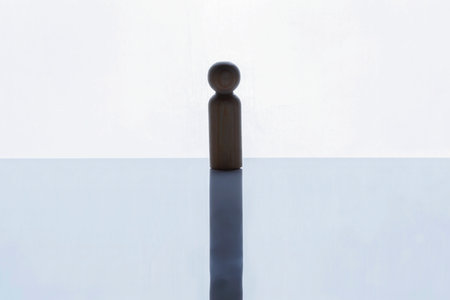 Closeup view of a brown wooden figure standing on a white background. Human resources management...