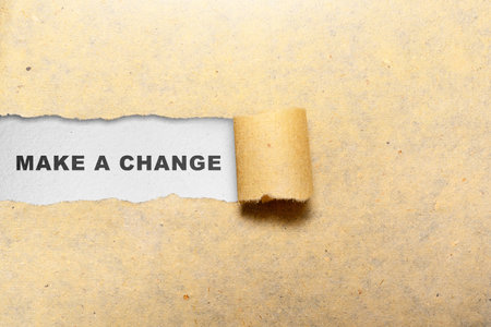 Ripped paper with the text of make a change over a white background. Change and innovation conceptの写真素材