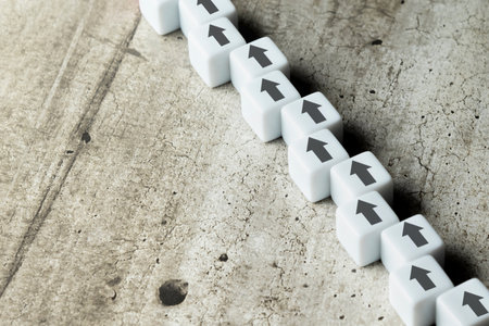 The row of cubes with one direction ahead on the table. Business strategy concept