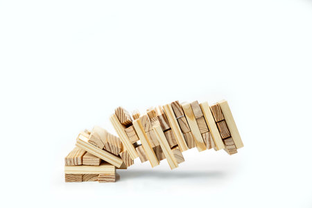 Closeup view of the tower of the wooden block almost falls on a white background.