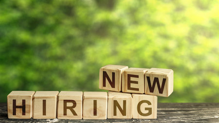 Wooden blocks with employee symbols with the message new hiring with green background. Open recruitment and business concept. Idea for corporation for new hiring.の写真素材