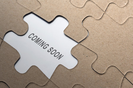Piece of missing jigsaw puzzle with 'coming soon' text on a white background. New conceptの写真素材