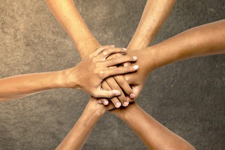 Closeup view of people stacking their hands together for unity and teamwork. Collaboration conceptの写真素材
