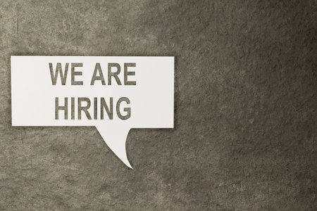 Paper with the text of We are hiring on a black background. Business, job, and career concept