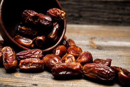 Dried dates fruit for iftar on Ramadan in the bowl on a wooden tableの写真素材