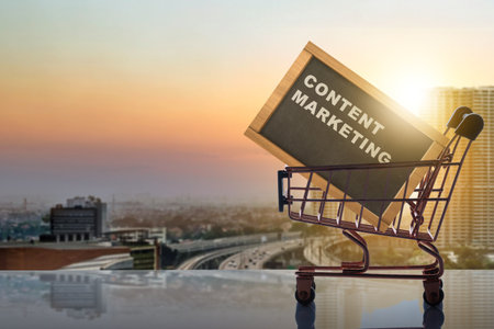Shopping cart carrying blackboard with content marketing text with cityscapes background. Content manager, strategy and creativity conceptの写真素材