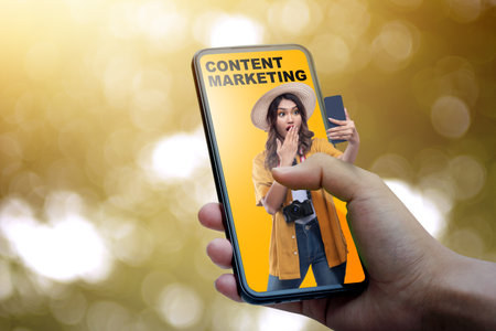 Human hand holding mobile phone with a view of traveler woman and content marketing text on a...