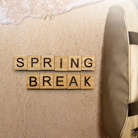 Bag and wooden cubes with Spring Break text on the sandy beach. Spring break conceptの写真素材