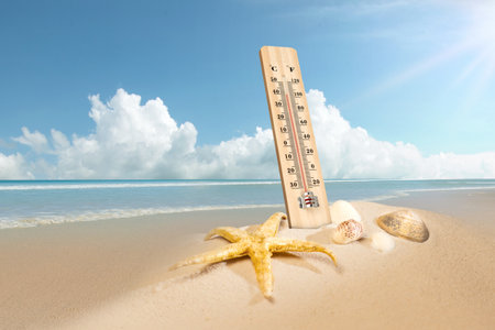 Thermometer with hot temperature on the beach. Environment, global warming, and climate change conceptの写真素材