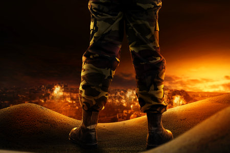 Soldier feet with military boots standing with fire and explosion on war scene backgroundの写真素材