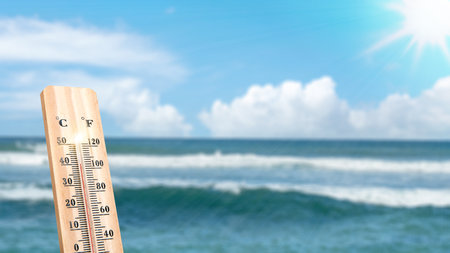 Thermometer with hot temperature on the beach. Environment, global warming, and climate change conceptの写真素材