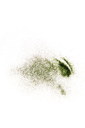 Closeup view of green glitter on a white backgroundの写真素材