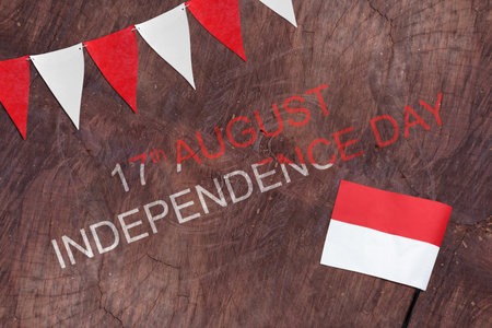 Indonesian flag ornament with message of 17th August Independence Day on wooden background