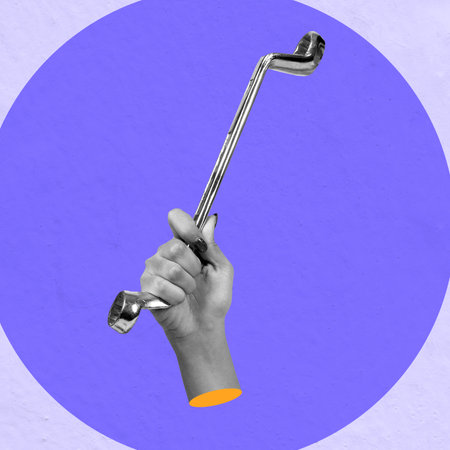 A human hand holding a wrench on a colored background. Collage artの写真素材
