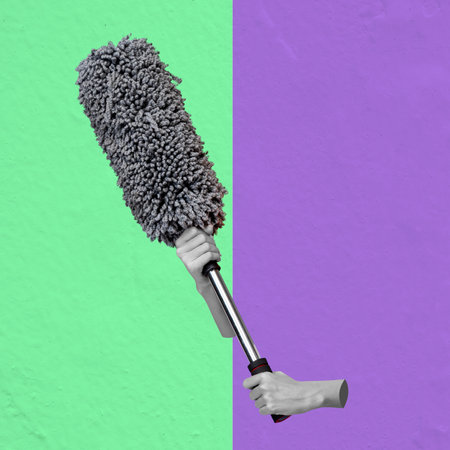 A human hand holding a duster on a colored background. Collage artの写真素材