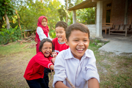 Portrait of Indonesian kids celebrate Indonesia Independence Day with traditional events like a tug of war contest outdoorの写真素材