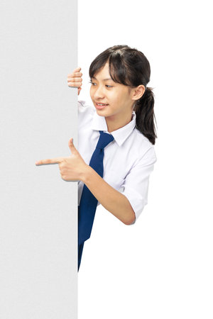 A girl pointing to a white board. She is wearing a blue tie isolated over white backgroundの写真素材