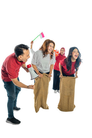 A group of people are playing a game of sack race. Scene is lighthearted and fun. Indonesian...