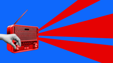 A red and blue radio with a hand pointing at itの写真素材