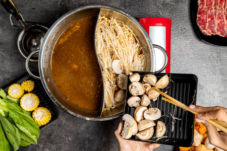 A person is cooking a dish with mushrooms and corn on a counter. The dish is in a pot with a lid on...