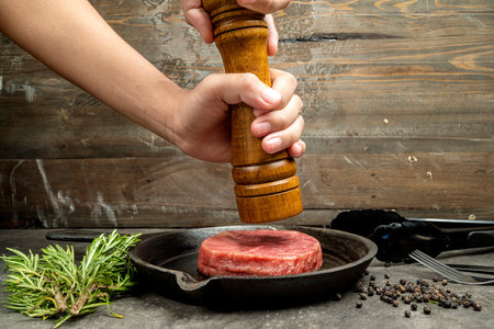 A person is grinding tenderloin meat with a pepper millの写真素材