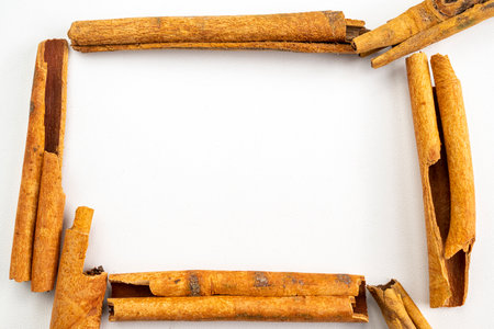 A close up of cinnamon sticks arranged in a square. The sticks are brown and appear to be freshly cut. Concept of warmth and comfort, as cinnamon is often associated with cozy winter monthsの写真素材