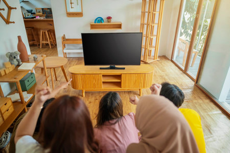 An Indonesian group of people are playing video games in a living room. The scene is fun and lightheartedの写真素材