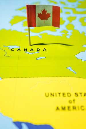 A map of Canada with a Canadian flag on it. The flag with maple leaf and red and white color. Travel and government conceptの写真素材