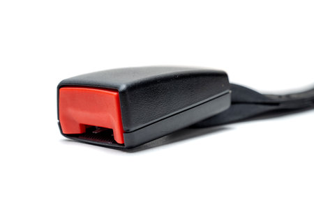 A close up of a red and black car seatbelt isolated over a white background