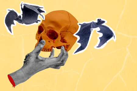 Hand holding human head skull with bats flying around it. The skull is in the middle of the image...