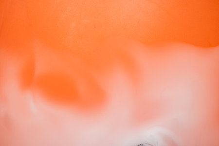 A bright orange background with white smoke in the foreground. Dramatic smoke or fog effect. Mockup....