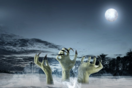 Group of witch hand with long black nail coming out of fog with a full moon in the background. The hand appearing to be a evil, satan, zombie or a monster hand. Spooky Halloween conceptの写真素材