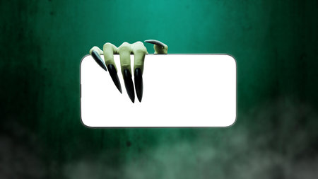 Witch hand with long black nail holding mobile phone or cell phone. Blank mobile phone screen for...