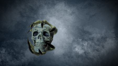 Witch hand with long black nail holding human head skull through smoke, gives the image a spooky and scary mood. Evil, satan, zombie or monster hand. Spooky Halloween conceptの写真素材