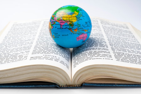 Opened book of Holy Bible with globe. It is laying on white background. Symbol of faith and worship in God. Religious christian service, missionary, holiday or conceptの写真素材