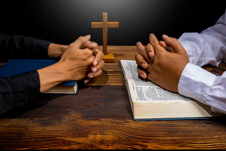 Man praying together with religion cross and on a opened holy bible. Symbol of faith and worship in God. People christianity prayer in church. Religious service, holiday or conceptの写真素材