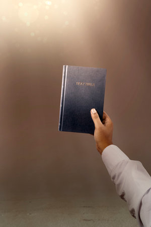 Man holding a holy bible in his hand. Symbol of faith and worship in God. People christianity...