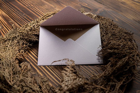 Envelope and postcard with brown card with words Congratulations on it with wreath. Congratulations message for business, birthday party, party, festivity or celebration conceptの写真素材