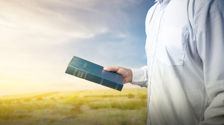 Man holding a holy bible in his hand. Symbol of faith and worship in God. People christianity...