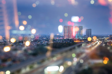 View of street traffic with building and modern city skyline with colorful bokeh light background....