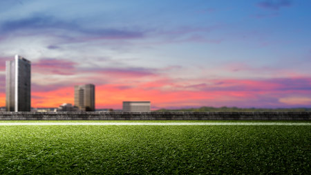Empty football field with pitch line on green grass with cityscapes. The field is ready for a game. Concept of Professional sport, Competition, Championship and match. Soccer stadium field backgroundの写真素材