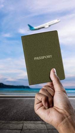 Human hand holding a passport with flying commercial airplane in the sky background. Travel by airplane conceptの写真素材
