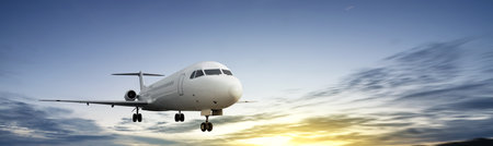 Commercial airplane flying in the sky with cloudscapes in the sunrise scene background. Travel by airplane conceptの写真素材