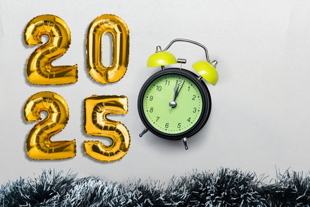 Golden helium balloons with the number 2025 and an alarm clock on a white background. Happy New Year concept or Celebrationの写真素材